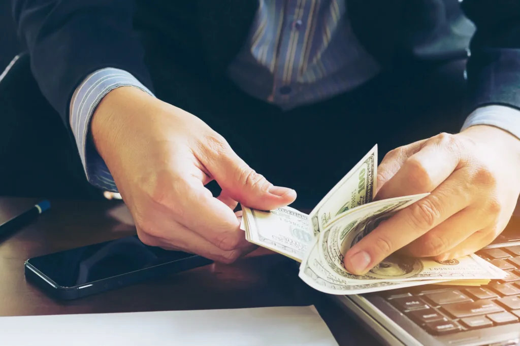 Business owner counting cash for business cash flow management